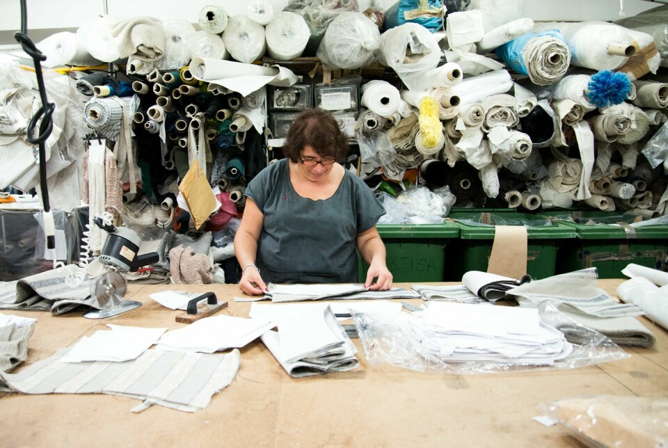 kvinne foran en hylle full av tekstilruller