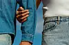 detaljbilde av to personer ikledd denim