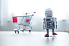 Online-Shopping concept: Toy robot and Miniature shopping cart