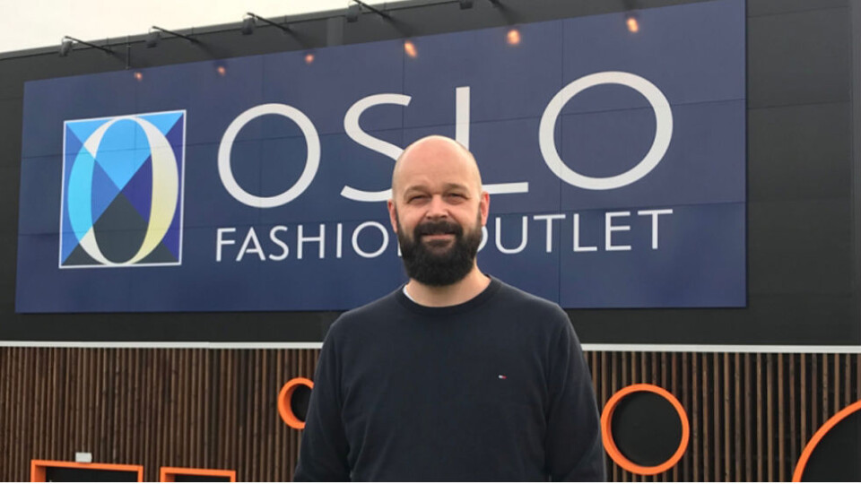 Senterleder Lars Pedersen foran den nye logoen